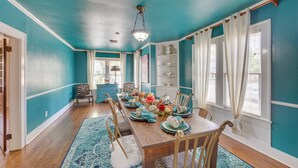 A dining room with teal walls, a wooden table set for six, and a chandelier. - 'The Pink Azalea' - Tyler Home w/ Yard + Patio! (Tyler)