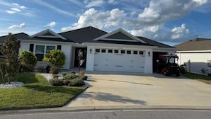 A single-story house with a garage, a driveway, and a well-maintained lawn.