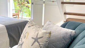 A bedroom with a bed, a window with a view of greenery, and a staircase. - Punta Popy Boutique Hotel (Las Terrenas)