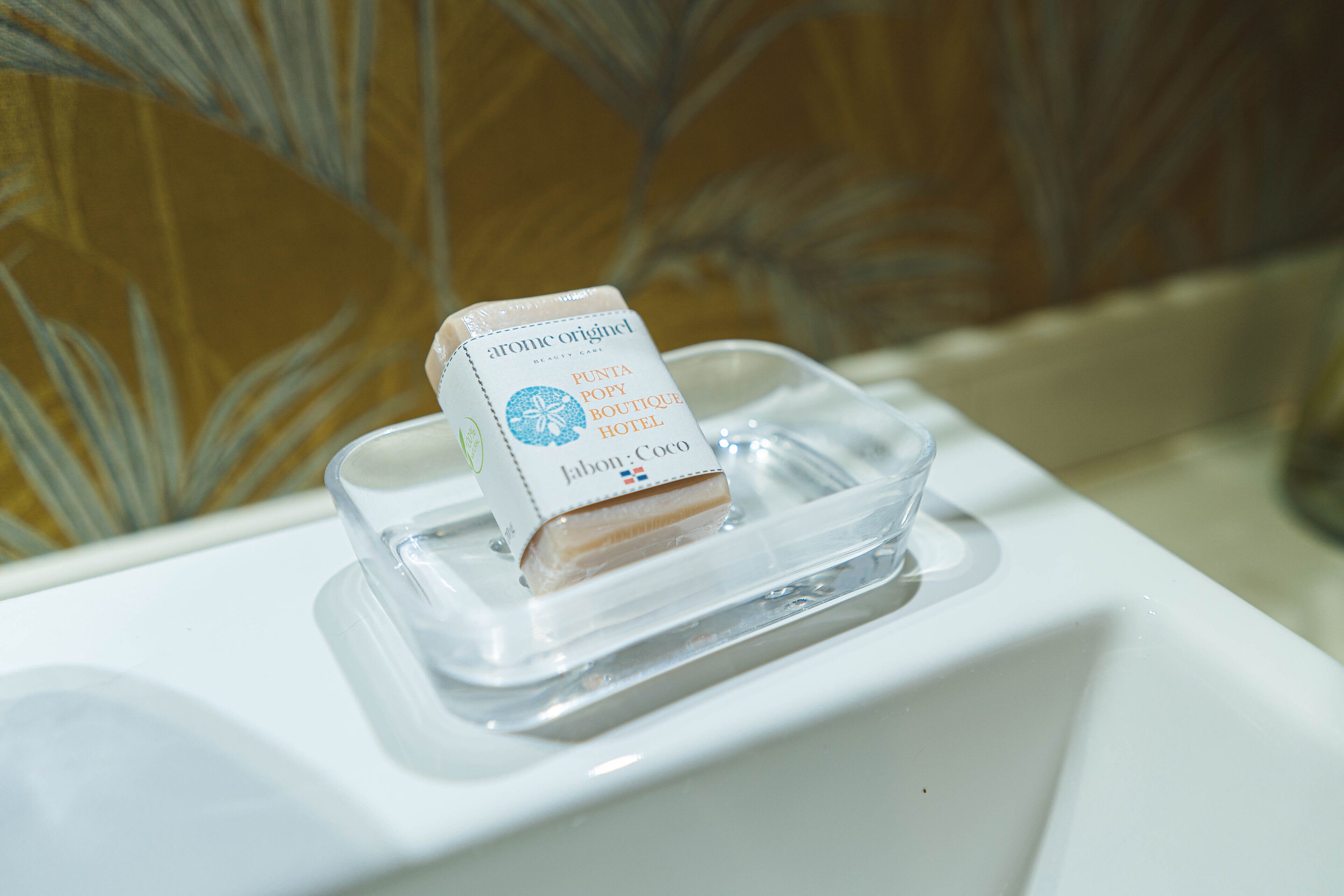 Een zeepstuk in een transparante plastic bak op een witte wasbak.