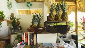A wooden table with books, a bowl, and three pineapples. - Punta Popy Boutique Hotel (Las Terrenas)