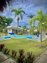 Una piscina al aire libre, sombrillas, sillones reclinables de piscina