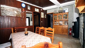 A dining room with a wooden table and chairs, a large mirror, and a cabinet with glass doors. - Holiday Home Serov - four bedroom house (Tisno)