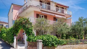 A multi-story residential building with balconies, a gated entrance, and surrounding greenery. - Apartments Maretic Brodarica A1 (Šibenik-Brodarica)
