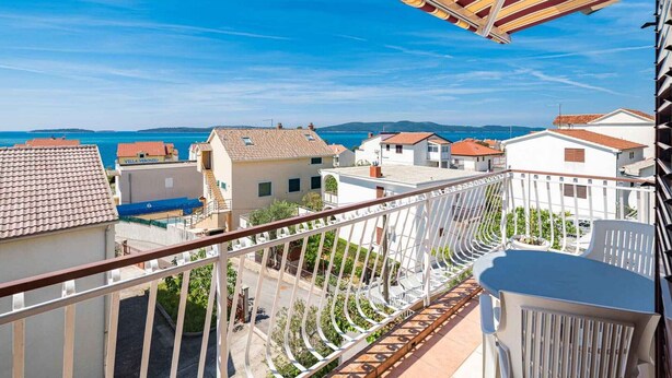 Un balcon avec vue sur la mer et les bâtiments.