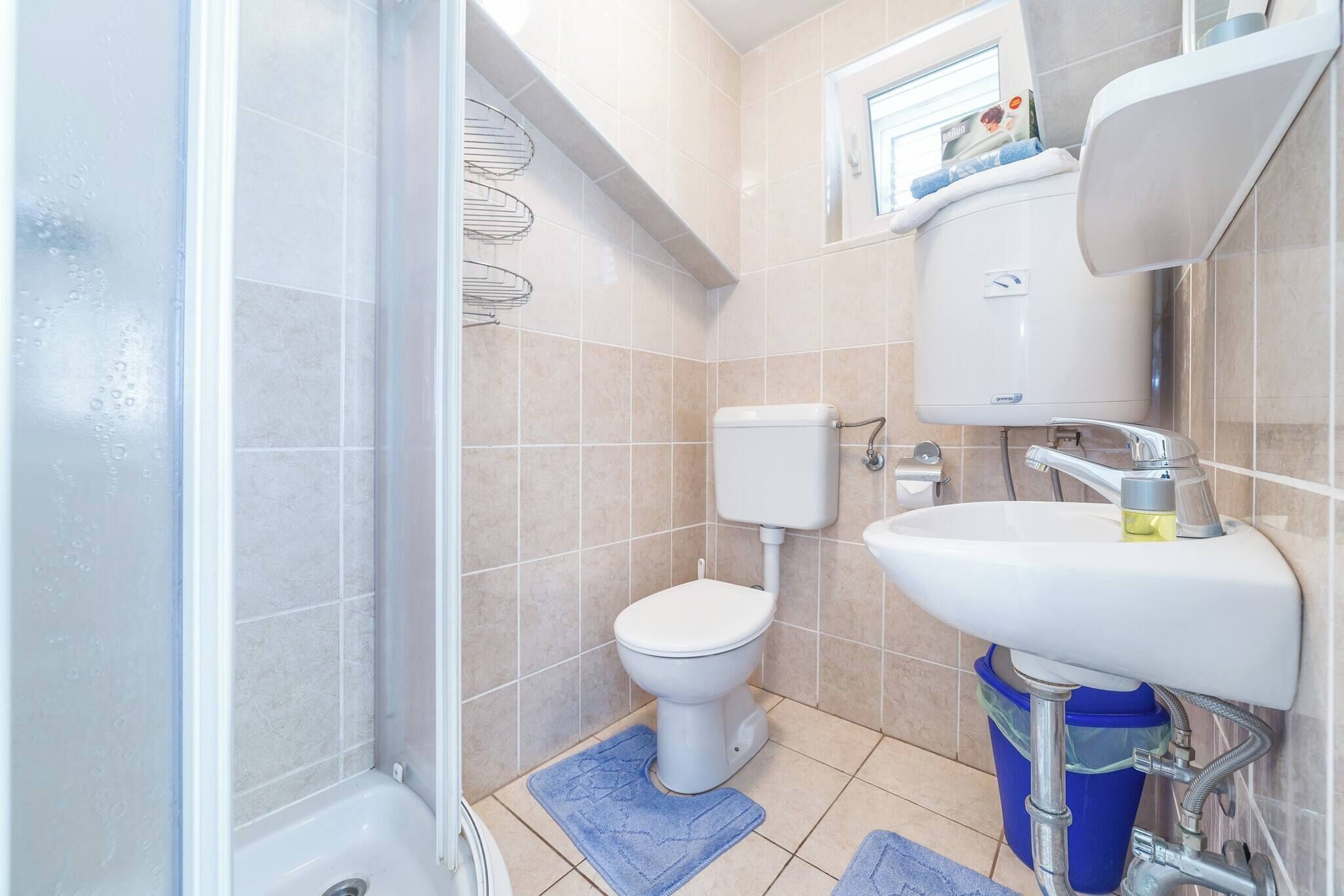 A bathroom with a toilet, sink, and shower.