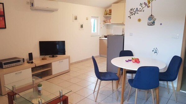 Cozy living space with a flat-screen TV, dining area, and comfortable seating for four.