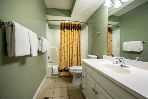 Un baño con lavamanos blanco, inodoro y cortina de ducha.