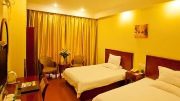 Quarto de hotel com duas camas, uma mesa de trabalho com telefone e uma cadeira.