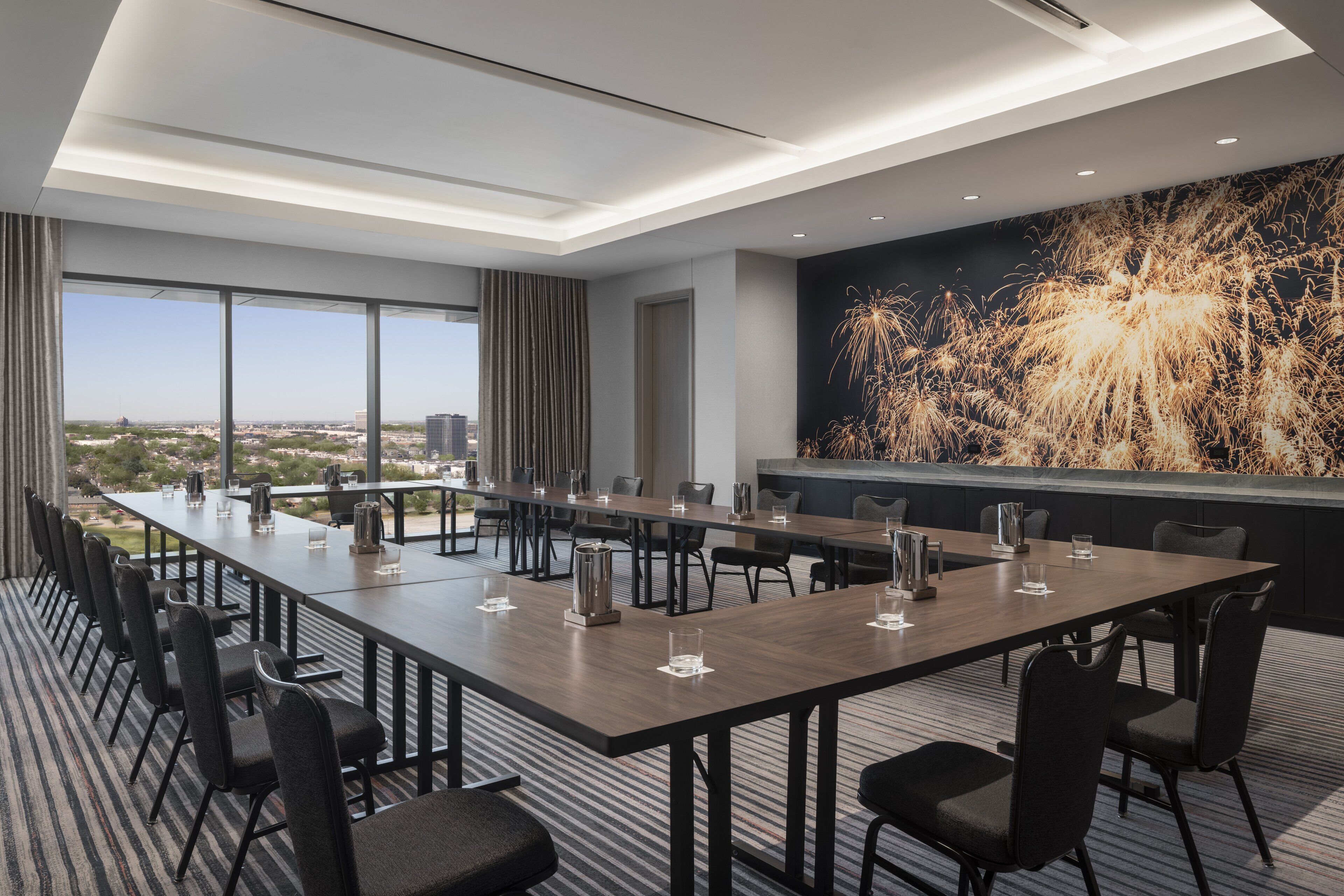 Une salle de conférence dotée d’une longue table, de chaises et offrant une vue sur la ville grâce à de grandes fenêtres.