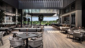 A spacious outdoor dining area with modern furniture and a view of the landscape.
