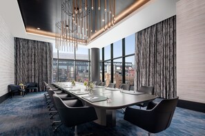 A conference room with a long table, chairs, and a city view through large windows. - Loews Arlington (Arlington)