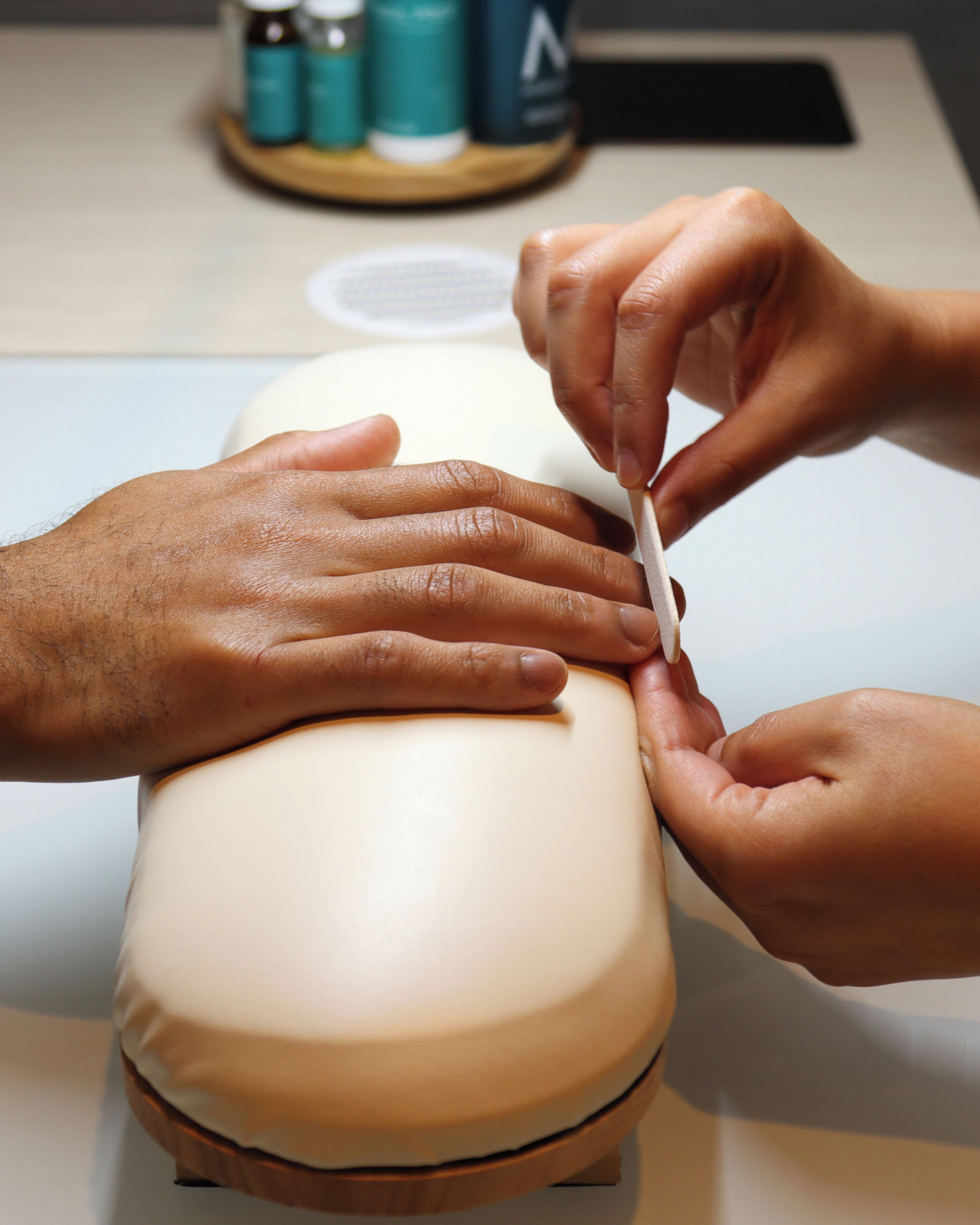 A person using a nail file on another person's hand.