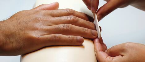 A person using a nail file on another person's hand.