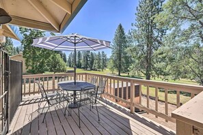 Relax on the deck with a round table and four chairs, shaded by a large umbrella.