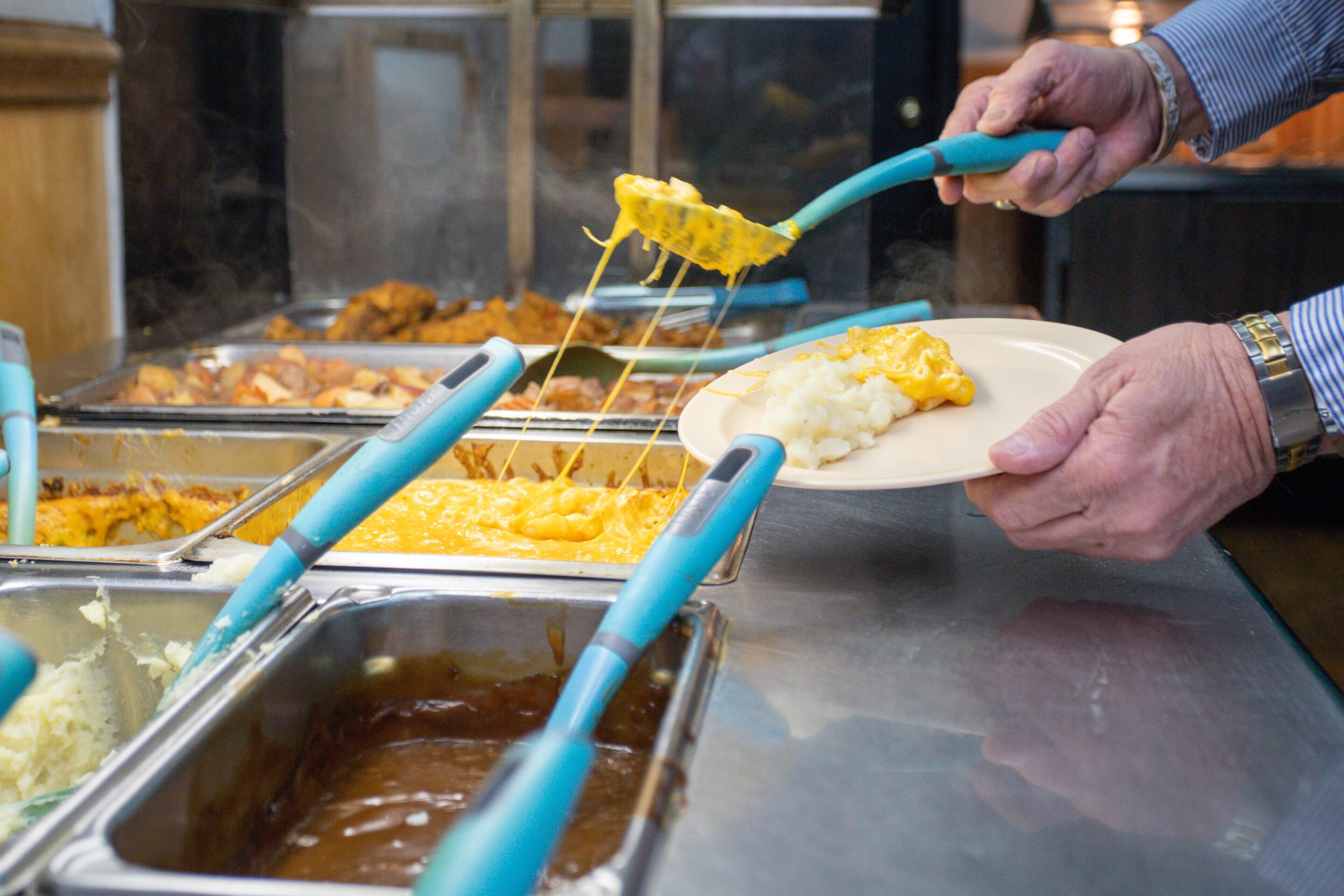 A buffet with various food items and utensils.