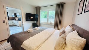 Une chambre d’hôtel avec un lit, une télévision, une fenêtre avec des rideaux et une vue sur l’extérieur.