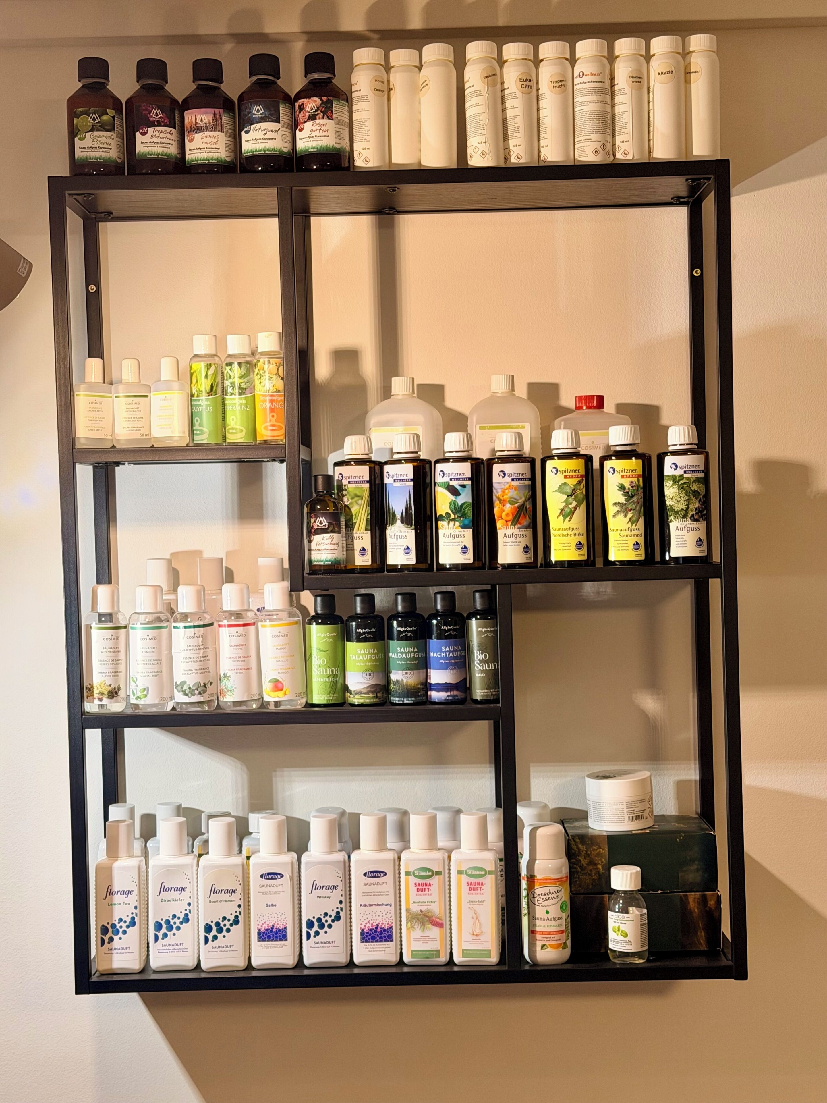 Une étagère fixée au mur, sur laquelle sont disposées différentes bouteilles de produits de soins personnels.
