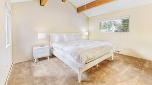 Una camera da letto con un letto, comodini, una ventola a soffitto e una finestra.