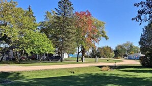 A residential area with houses, a driveway, and a lawn. - Rustic Retreat Cottage sleeps 6 with a lake view! (Worth Township)