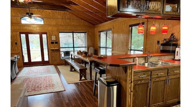 Une cuisine spacieuse avec des meubles en bois, un grand îlot central et un coin repas équipé d’une banquette.