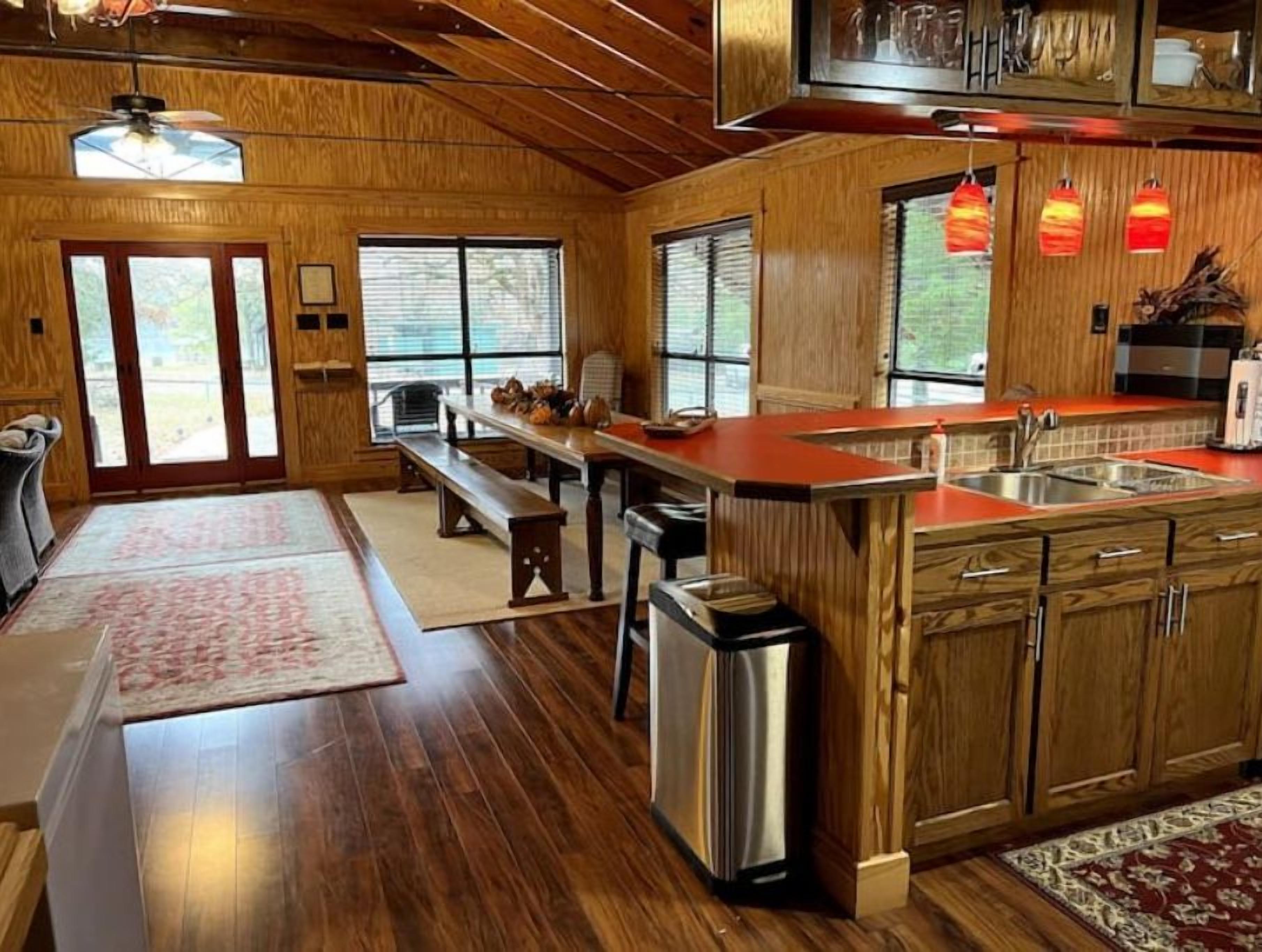 Una cocina amplia con armarios de madera, una isla grande y una zona de comedor con banco.