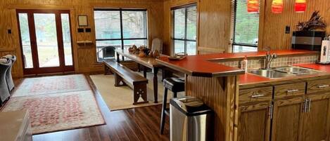 A spacious kitchen with wooden cabinets, a large island, and a dining area with a bench.