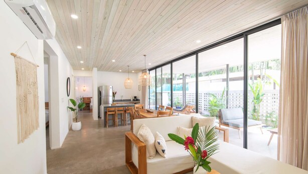 A modern living room with a sofa, a dining area, and a kitchen. - Villa Arlen - Brand new - Pool - Spacious (Mal País de Cobano)