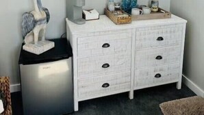 A white dresser with drawers and knobs, a coffee maker, a sculpture, and various items on top. - New Floating Luxury: Unique Houseboat Retreat (Orange Park)