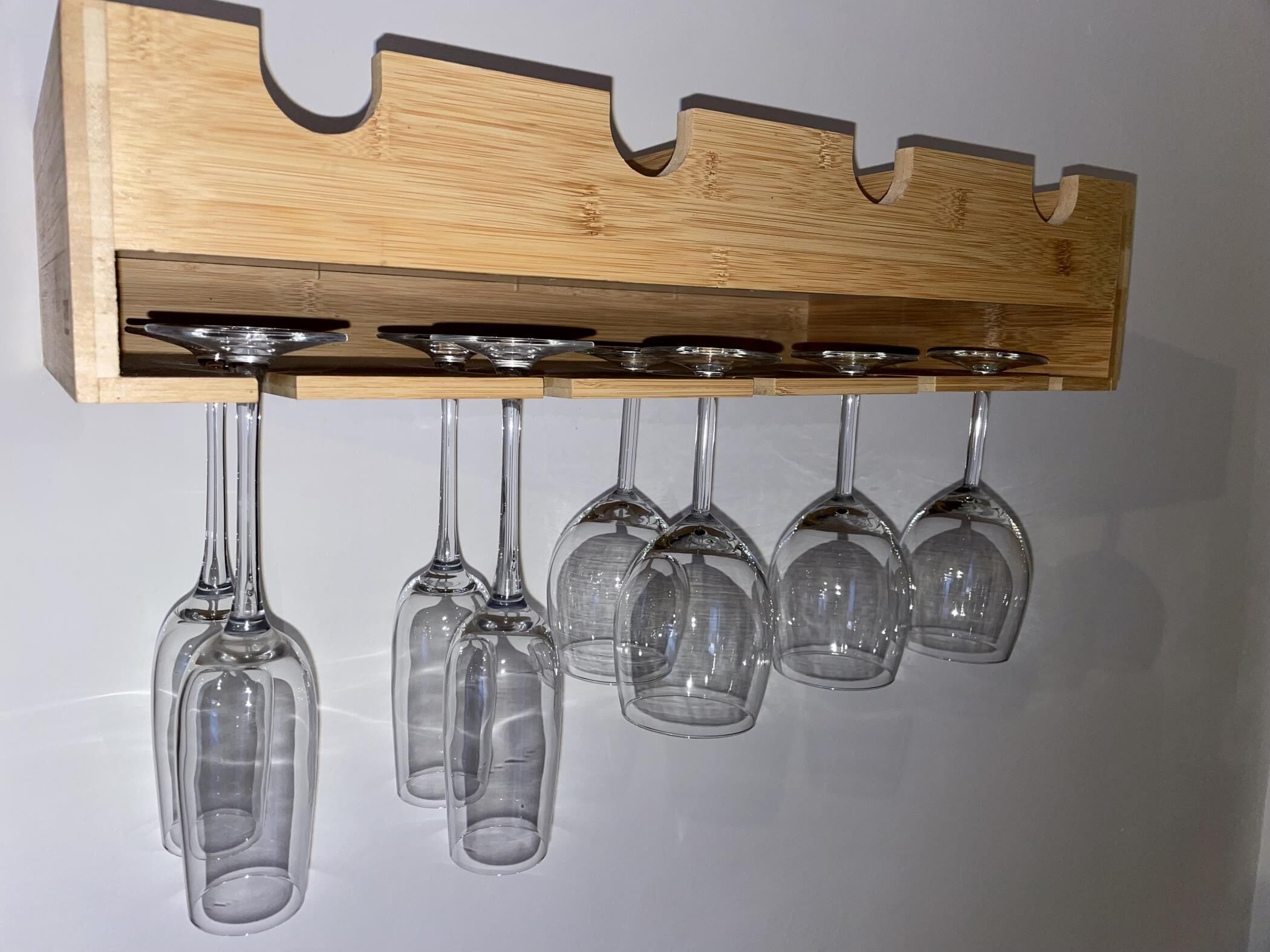 Una botellera de madera con seis copas de vino.