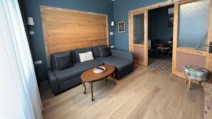 A living room with a sofa, a coffee table, and a patterned stool. - Istanbul Gem: 3-Bedroom Apartment with Panoramic Terrace and Iconic Sea Views (İstanbul)