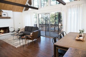 Relax in this stylish living area with a sofa set, coffee table, and dining table, perfect for enjoying meals and company.