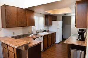 Kitchen features a dishwasher, stainless steel sink, refrigerator, and coffee maker.