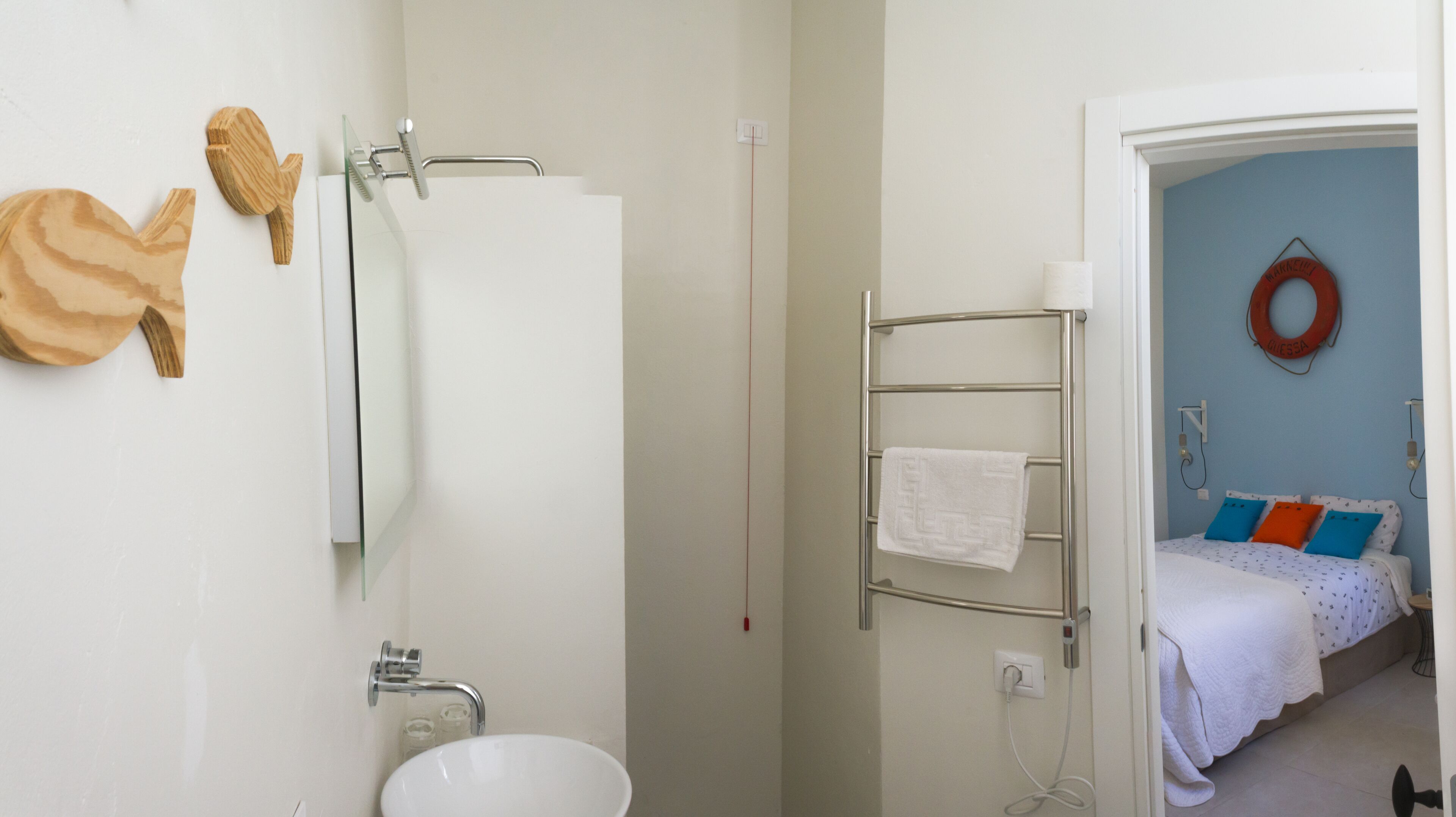 A bathroom with a white sink, a glass shower enclosure, and a towel rack.