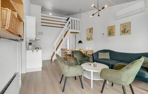 Ein zeitgemäßer Wohnraum mit Treppe, Essbereich und Sitzgelegenheiten.