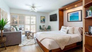 Un dormitorio con cama, sofá, mesa de comedor y sillas.