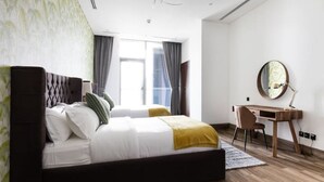 Un dormitorio moderno con una cama grande, un escritorio y un espejo.