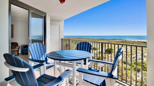 A balcony with a table and chairs, overlooking a beach. - Phoenix VI 201 | Orange Beach, AL (Orange Beach)