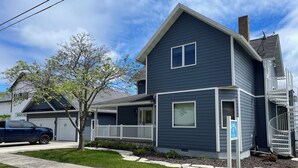A two-story residential building with a dark blue exterior, white trim, and a small porch.
