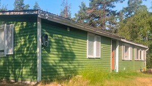Een groene stacaravan met een klein terras en één deur.