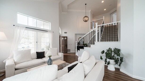 A spacious living room with a high ceiling, a staircase, and a view of the outside. - Villa Paloma::Private escape with Pool & Hottub (Oceanside)
