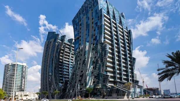 Ein modernes Hochhaus mit einem einzigartigen, winkelförmigen Design und einer reflektierenden Glasfassade.