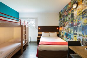 Una habitación con una cama alta, una cama individual, un escritorio y una pared decorada con carteles de viaje.