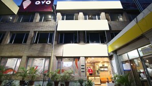 A hotel with a prominent 'OYO' sign, multiple windows, and a reception area with a counter and seating. - OYO Rooms 099 Ram Talai Temple (Amritsar)