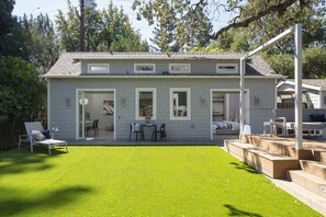 Een woonhuis met twee verdiepingen, een overdekt terras, een kleine tuin en een omheinde achtertuin.