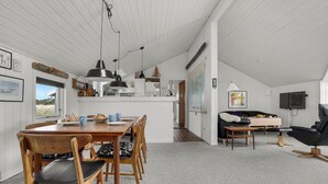A spacious living area with a dining table, chairs, a sofa, and a TV. - Amazing home in Thisted with sauna (Thisted)