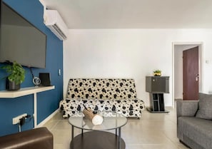 Relax in this stylish living room with a flat-screen TV, comfortable sofas, and a glass coffee table.