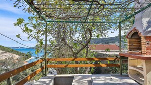 A balcony with a view of the sea, a brick oven, and a wooden railing. - Awesome apartment in Marina with lake view (Marina)