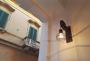 A building facade with a balcony and a wall-mounted light fixture. - Single-family home in the center of Appartement Cardille (Monopoli)