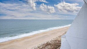 Vista de la playa con un edificio blanco al frente.